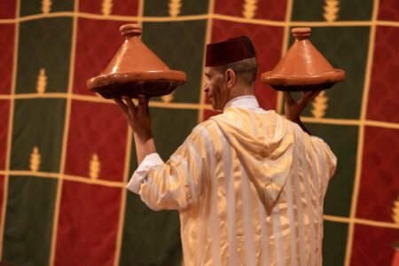 Restaurant chez ali marrakech a man holding two clay pots